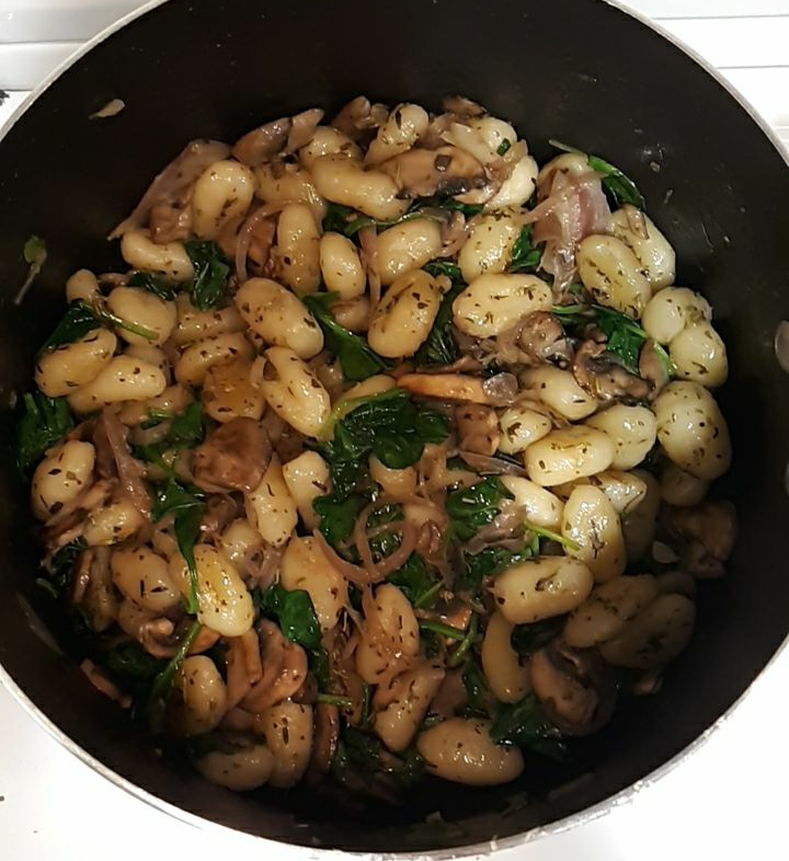Image of gnocchi in a pot with spinach and mushrooms